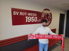 Aryan mit dem RWM Schal vorm Logo