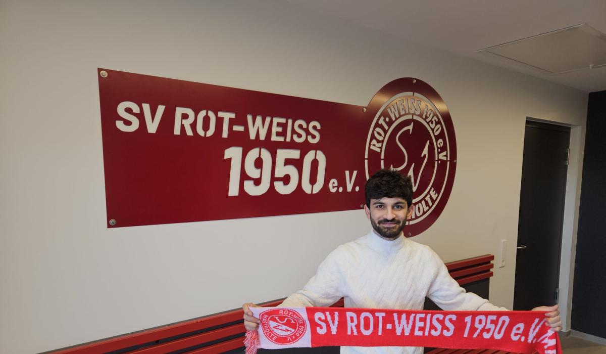 Aryan mit dem RWM Schal vorm Logo
